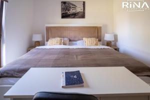 een slaapkamer met een bed met een boek op een tafel bij Kuća za odmor Rina in Pakrac