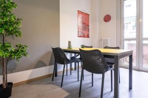 une table à manger avec des chaises et une horloge murale dans l'établissement [700mStazioneCentrale]Ampio Trilocale con 2Balconi, à Trieste
