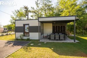 a small house with a patio and grass at Kuća za odmor Rina in Pakrac
