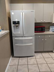 - un réfrigérateur blanc dans une cuisine avec des placards blancs dans l'établissement Snowbirds escape / vacation gateway #a, à Englewood