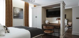 een hotelkamer met een bed, een bureau en een televisie bij King Street Aparthotel in Stirling