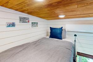 Bett in einem kleinen Zimmer mit Holzdecke in der Unterkunft Tiny Tiger in Issaquah