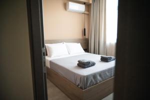 CENTRAL OLD TOWN- LADADIKA APARTMENT في سلانيك: غرفة نوم عليها سرير وفوط