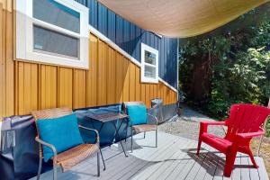 eine Terrasse mit Stühlen, einem Tisch und einem roten Stuhl in der Unterkunft Tiny Tiger in Issaquah