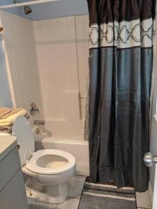 y baño con aseo y cortina de ducha. en Snowbirds escape / vacation gateway #a en Englewood