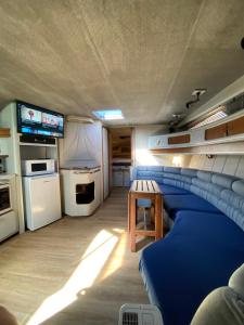 a living room with a blue couch and a table at Yate en Gijon , experiencia única B in Gijón