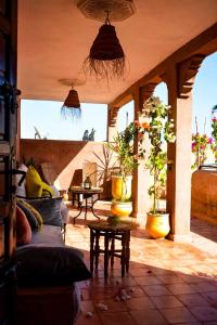 een woonkamer met een bank en potplanten bij Dar Tuscia in Marrakesh