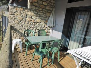 a table and chairs on a patio with a stone wall at Domaine Aigoual Cevennes in Meyrueis