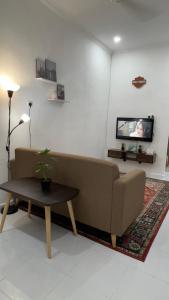 salon z kanapą i telewizorem w obiekcie Rezeki indah Hstay self check in w mieście Bukit Mertajam