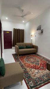 uma sala de estar com um sofá e um tapete em Rezeki indah Hstay self check in em Bukit Mertajam