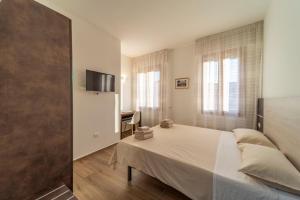 een slaapkamer met een bed en een tv aan de muur bij Mentana Rooms in Parma