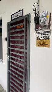 una porta rossa sul lato di un edificio di Rezeki indah Hstay self check in a Bukit Mertajam
