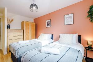 2 camas en una habitación con paredes de color naranja en Central Mcr apt near AO arena, parking available nearby en Mánchester