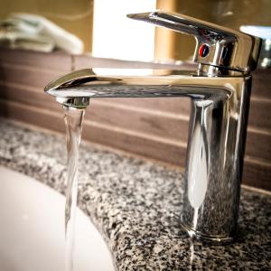 a sink with water running from a faucet at Armeno beach hotel in Nydri