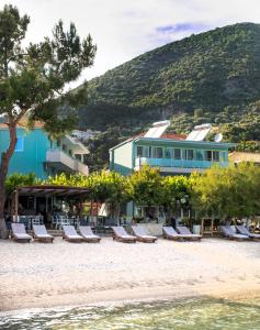 a group of lounge chairs on the beach in front of a building at Armeno beach hotel in Nydri