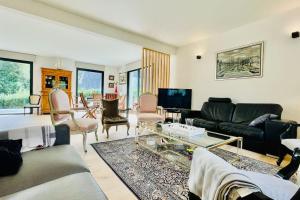 ein Wohnzimmer mit einem Sofa und einem Tisch in der Unterkunft Ti Bras - la grande maison in Crozon