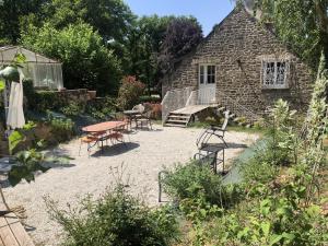 einen Garten mit einem Tisch und Stühlen sowie ein Gebäude in der Unterkunft Le Mariotte 