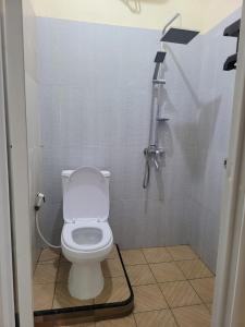 a bathroom with a toilet and a shower at Solo Nadamax City Guest House Syariah in Bonorejo