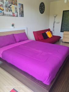 a large pink bed in a room with a couch at The Naithorn Condo Unit 401 in Nai Thon Beach