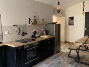 een keuken met een wastafel en een fornuis top oven bij Du Vent Dans Les Arbres -120m2 Belle vue sur le lac in Chindrieux