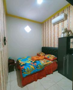 um quarto com uma cama com um edredão colorido em Felix guest house em Tegal