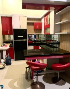 een keuken met rode kasten en een zwart aanrecht bij Felix guest house in Tegal
