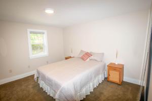 ein weißes Schlafzimmer mit einem Bett und einem Fenster in der Unterkunft Large Beautiful Apartment (Unit 40) in Hershey