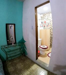 uma casa de banho com um espelho e um WC. em Casarão Hostel e Pousada em Abraão