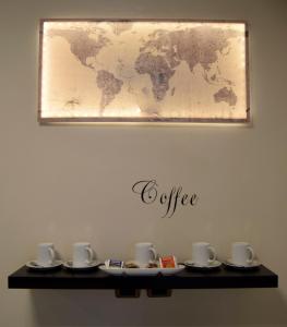 un tavolo con tazze e piattini e una mappa del mondo sul muro di Holiday a San Pietro a Roma
