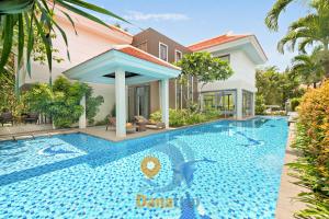 a swimming pool in front of a house at Danang Amazing Ocean Beach Resort in Da Nang