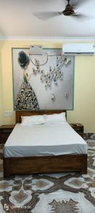 een slaapkamer met een bed met een schilderij aan de muur bij TITILI PLAZA in Puri