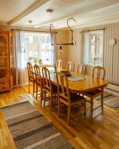una sala da pranzo con tavolo e sedie in legno di Reinefjorden Sjøhus a Reine