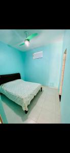 a bedroom with a bed and a ceiling fan at Casa de Temporada Arraial do cabo in Arraial do Cabo