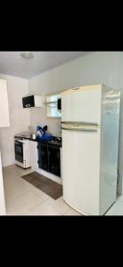 a kitchen with a white refrigerator and a stove at Casa de Temporada Arraial do cabo in Arraial do Cabo