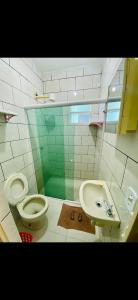 a bathroom with a toilet and a sink at Casa de Temporada Arraial do cabo in Arraial do Cabo