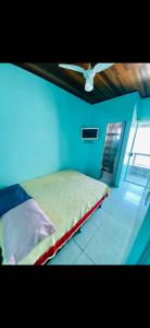 a bedroom with a bed with a ceiling fan at Casa de Temporada Arraial do cabo in Arraial do Cabo