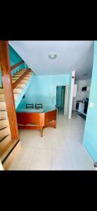 a living room with a staircase and a table at Casa de Temporada Arraial do cabo in Arraial do Cabo