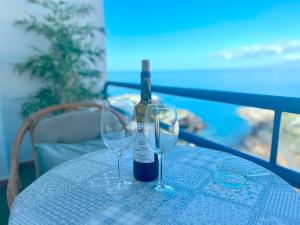 a bottle of wine sitting on a table with two glasses at Tropicalidays Paraiso del Sur in Adeje