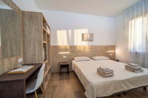 1 dormitorio con cama, mesa y escritorio en Mentana Rooms, en Parma