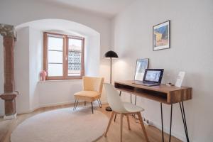 Cette chambre comprend un bureau avec un ordinateur portable et deux chaises. dans l'établissement Neues Design-Apartment, Altstadt, Business&Ferien, Küche, Netflix, à Bad Säckingen