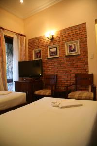 a hotel room with two beds and a television at Mui Ne Resort in Mui Ne