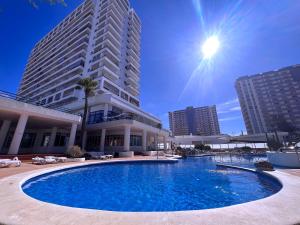 a large swimming pool in front of a tall building at Tropicalidays Paraiso del Sur in Adeje