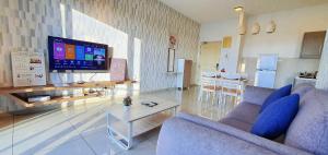 - un salon avec un canapé et une télévision dans l'établissement Atlantis Residence Melaka by YouBNB Homestay, à Malacca
