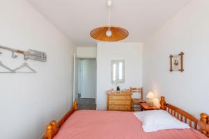 een slaapkamer met een bed met een roze sprei bij Le Trimaran 40 in Mers-les-Bains