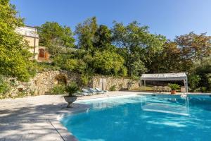 una piscina con sillas y una pared de piedra en Villa Magnolia 2, en Arcugnano