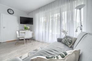 uma sala de estar com um sofá cinzento e uma mesa em Apartament Doris 3- Studio z wanną em Pobierowo
