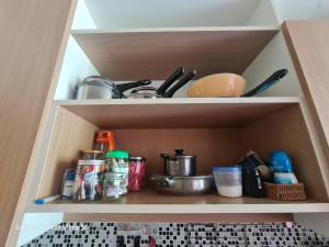 a cupboard with a kitchen utensils and dishes at The Naithorn Condo Unit 401 in Nai Thon Beach