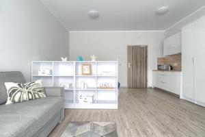 a living room with a couch and a kitchen at Apartament Doris 3- Studio z wanną in Pobierowo