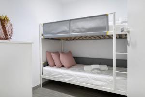 a white bunk bed with pink pillows on it at Casa Marion in El Golfo