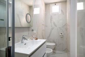 a white bathroom with a sink and a toilet at Casa Marion in El Golfo